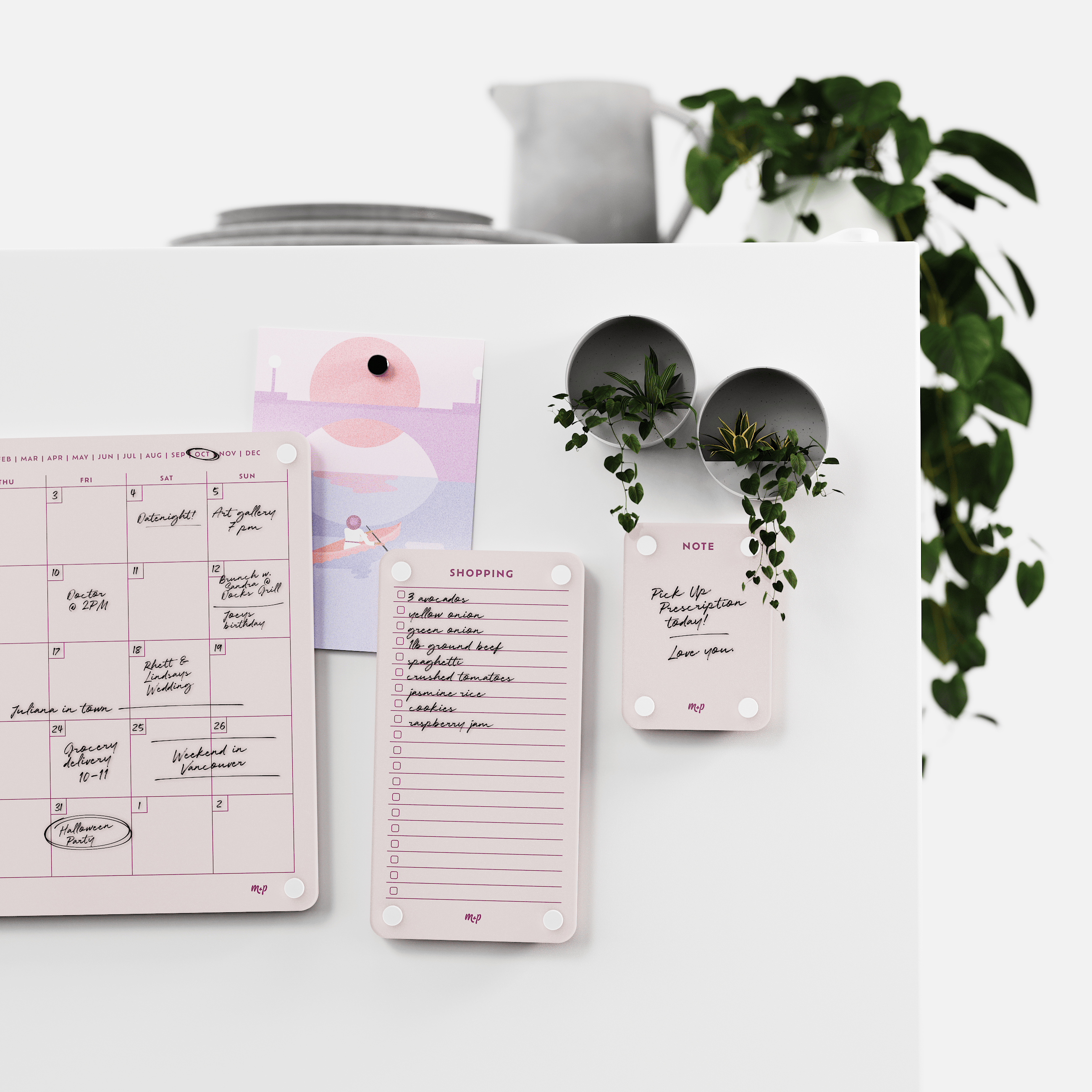Linen white monthly calendar, shopping list and note board on a white kitchen wall with magnetic planters